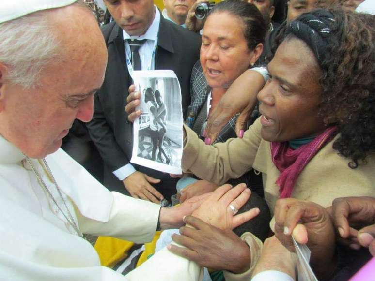 Norma Maria de Souza mostra reprodução de foto com o filho enquanto o Papa o abençoa. Mãe escreveu carta atrás da imagem.