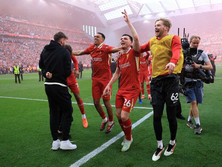 Trent Alexander-Arnold, Andrew Robertson e Caoimhin Kelleher, do Liverpool, comemoram a vitória da equipe e a confirmação do título da Premier League após a partida entre Liverpool FC e Tottenham Hotspur FC, em Anfield, em 27 de abril de 2025, em Liverpool, Inglaterra.