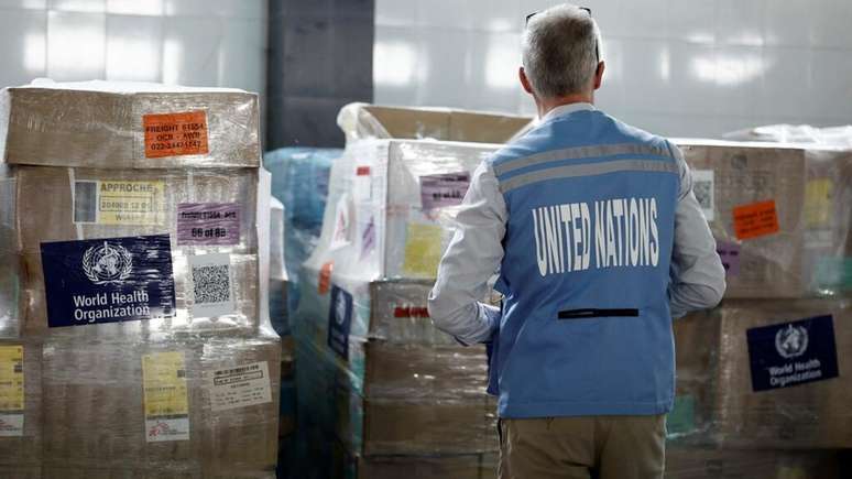 Um funcionário das Nações Unidas observa o estoque de ajuda humanitária destinado à Gaza e armazenado nas instalações do Crescente Vermelho Egípcio em El-Arish, na fronteira, em 8 de abril de 2025.