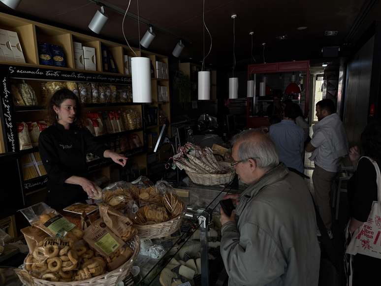 Consumidores fazem compras no escuro durante apagão em Barcelona, na Espanha, nesta segunda-feira, 28