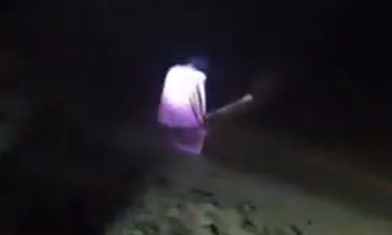 Mulher de roupa branca na beira da Praia da Ponta Negra, em Manaus
