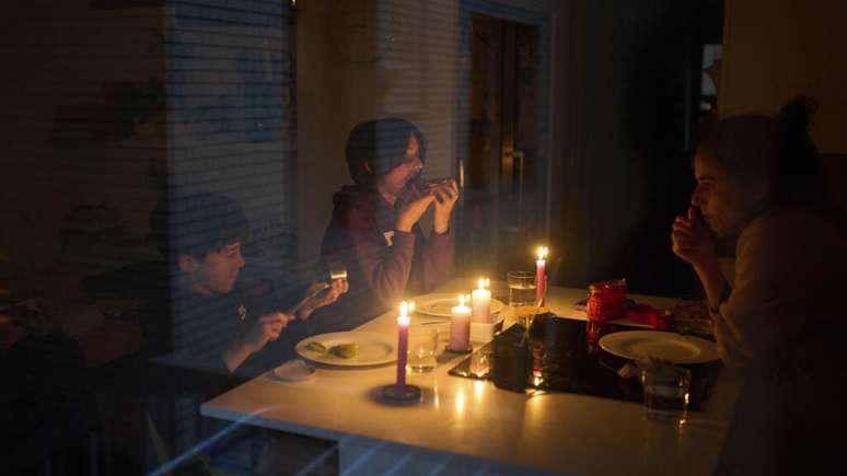 Família faz um lanche à luz de velas durante apagão em Barcelona, Espanha, na segunda-feira, 28 de abril de 2025. (Foto: Emilio Morenatti/AP)