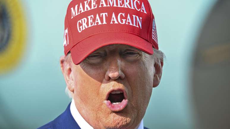 O ex-presidente Donald Trump fala com jornalistas após desembarcar no Aeroporto Internacional de Palm Beach, em West Palm Beach, Flórida, no domingo, 16 de fevereiro de 2025.