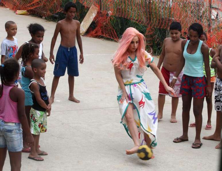 Lady Gaga joga futebol durante visita ao Morro Cantagalo, no Rio de Janeiro, em 2012.