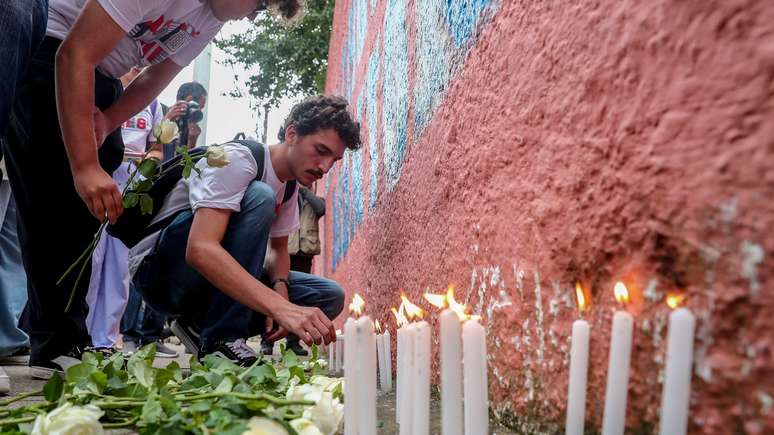 Velas e flores em muro da escola Thomazia Montoro, em S&atilde;o Paulo, onde professora foi assassinada em ataque em 2023