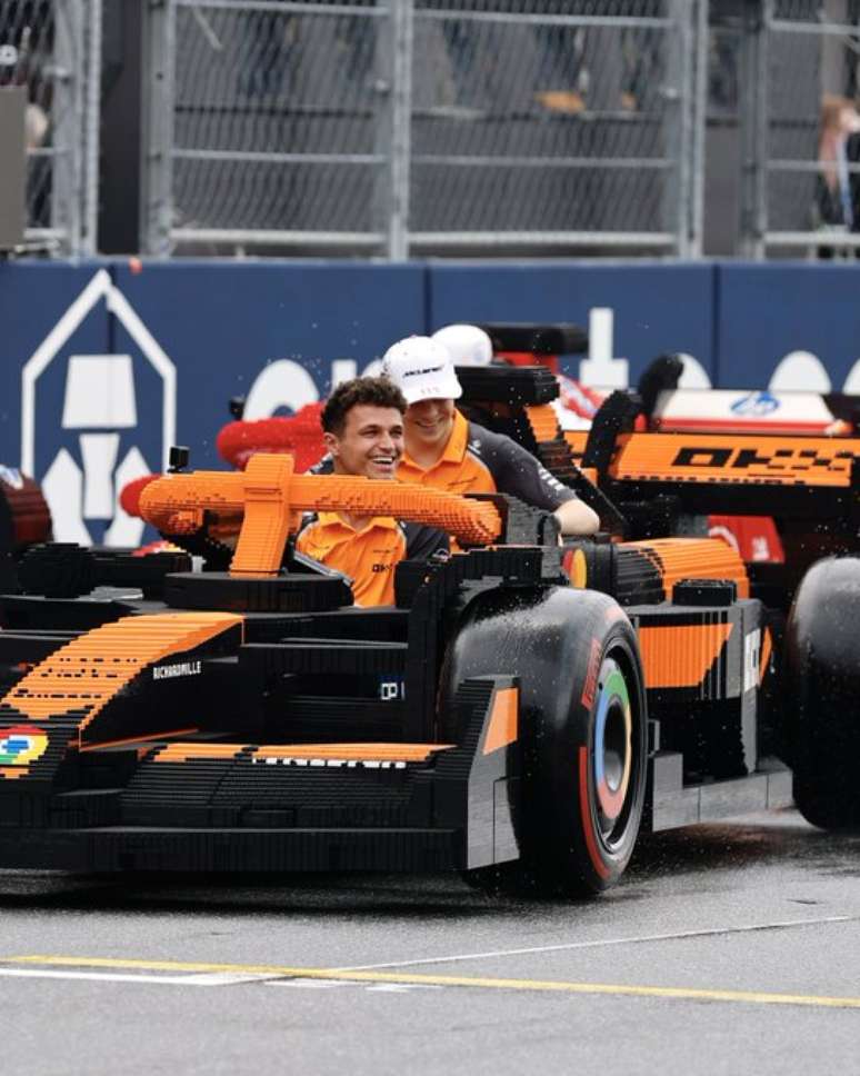 Lando Norris e Oscar Piastri durante desfile de pilotos em um carro de Lego 