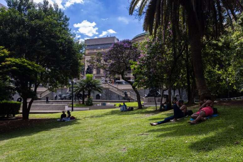 Pessoas aproveitam a sombra de árvore no Vale do Anhangabaú, região central de São Paulo, em dia de forte calor.