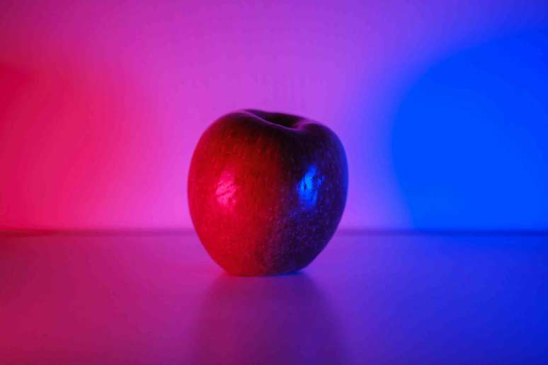 Ma&ccedil;&atilde; sob um gradiente de luz vermelha para azul