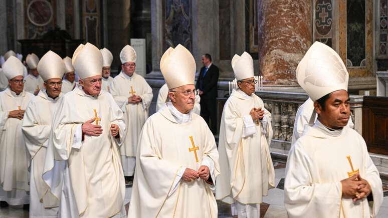 O cardeal italiano Fernando Filoni (C) e o cardeal timorense Virgílio do Carmo da Silva (D) participam da missa do Oitavo Novemdiale, após o funeral do papa e antes do conclave, na Basílica de São Pedro, no Vaticano, em 3 de maio de 2025. (Foto de Andreas SOLARO / AFP)