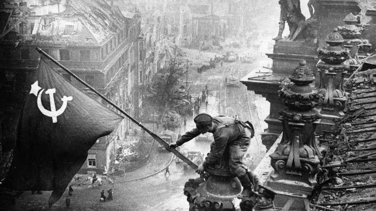 Soldados do Exército Vermelho hasteando a bandeira soviética no Reichstag em Berlim, Alemanha, 30 de abril de 1945, foto tirada por Vladimir Grebnev.