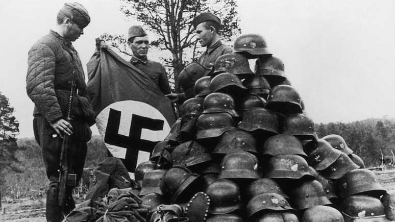 Soldados sovi&eacute;ticos empilham objetos capturados de seus inimigos alem&atilde;es em Murmansk, na R&uacute;ssia