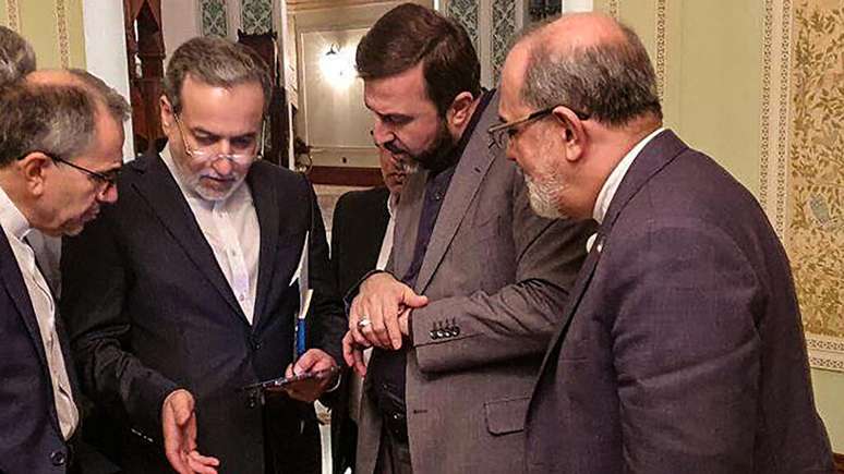 O ministro das Relações Exteriores iraniano Abbas Araghchi (2º à esquerda) conversa com membros da delegação iraniana, após as negociações nucleares do Irã com os Estados Unidos. Em Mascate, capital de Omã, em 12 de abril de 2025.