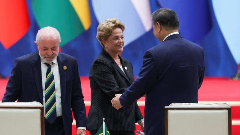 Dilma Rousseff, presidente do Novo Banco de Desenvolvimento e ex-presidente do Brasil, cumprimenta o presidente da China, Xi Jinping, ao lado do presidente do Brasil, Luiz Inácio Lula da Silva, enquanto eles participam da cerimônia de abertura da reunião ministerial do Fórum China-CELAC em Pequim, China, em 13 de maio de 2025.