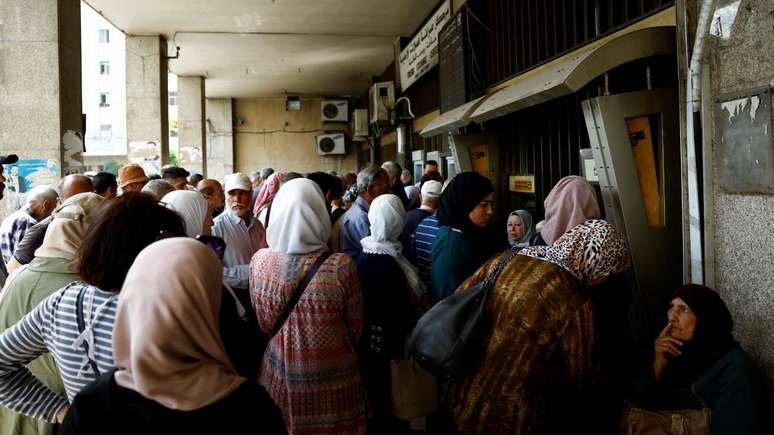 Pessoas se re&uacute;nem do lado de fora de um banco depois de Trump anunciar o fim das san&ccedil;&otilde;es &agrave; S&iacute;ria