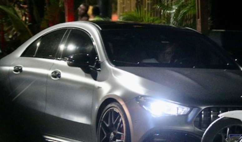 Em carro de luxo e de milhões, filho de Angélica e Luciano Huck deixa restaurante com namorada após jantar com amigos.