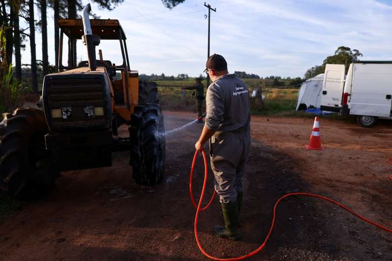 Homem limpa trator numa barreira sanitária em Montenegro (RS) Homem limpa trator numa barreira sanitária em Montenegro (RS)