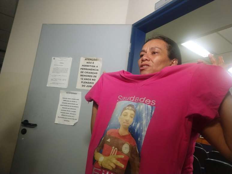 Zilda Regina de Paiva, mãe de jovem assassinado a pauladas em 2017, mostra imagem do filho em camiseta.