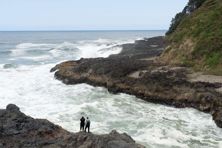 Pessoas fotografam mar agitado na costa dos Estados Unidos