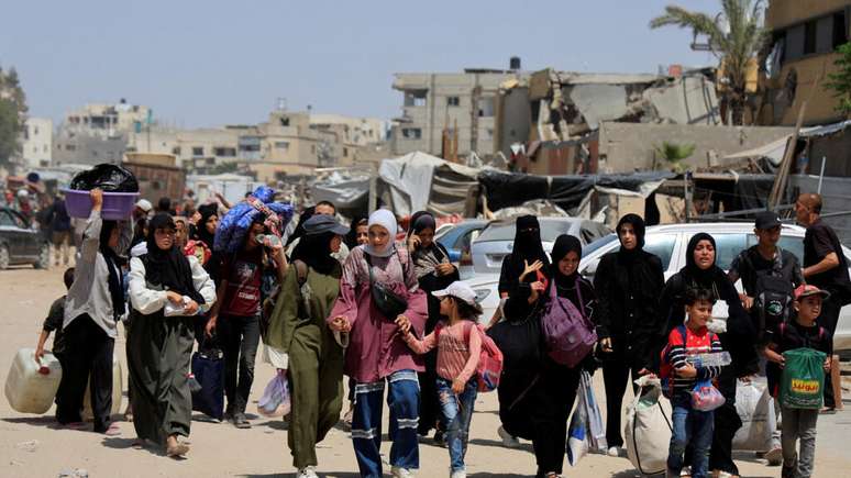 Palestinos levam seus pertences depois que o exército israelense deu a ordem de evacuação, no sul da Faixa de Gaza, em 19 de maio de 2025.
