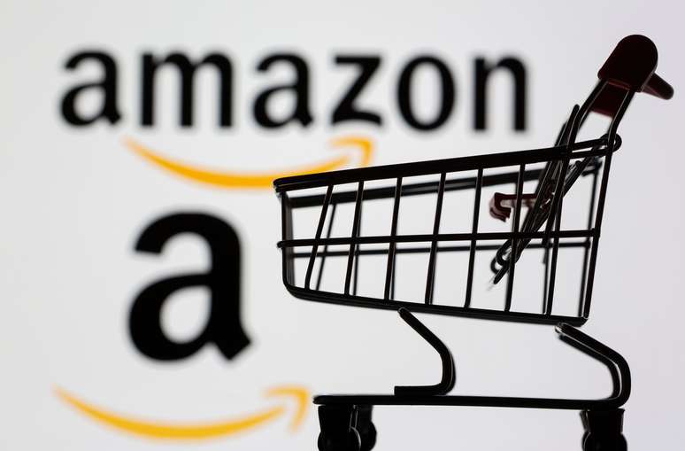 Logo da Amazon em telão atrás de carrinho de compras