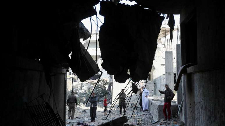 Palestinos inspecionam o local de um ataque israelense a uma casa em Jabalia, no norte da Faixa de Gaza, em 21 de maio de 2025.