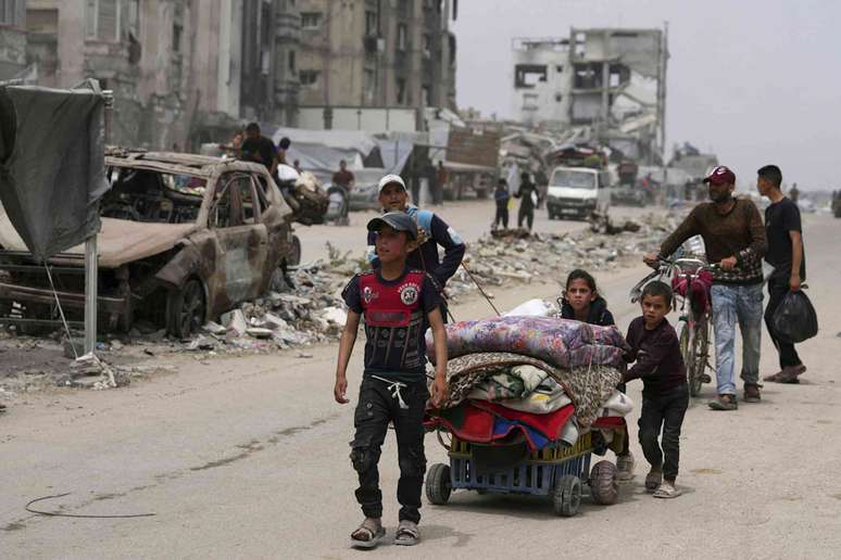 Palestinos deslocados que fogem em meio &agrave;s opera&ccedil;&otilde;es militares israelenses em andamento na Faixa de Gaza chegam a Jabalia, no norte de Gaza, em 18 de maio de 2025. AP Photo/Jehad Alshrafi