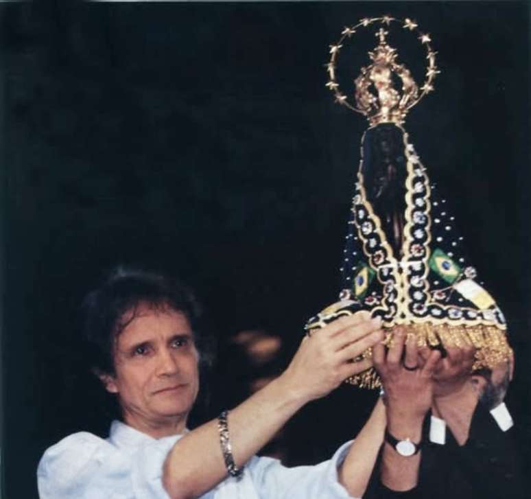 O cantor com uma imagem de Nossa Senhora Aparecida, representação de Maria no Brasil