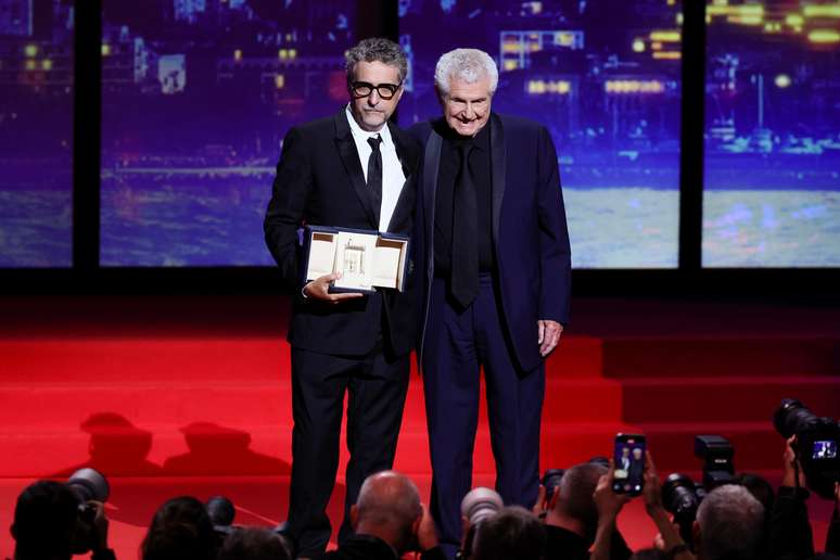 O diretor brasileiro Kleber Mendonça Filho aceitou o prêmio de Melhor Direção das mãos de Claude Lelouch