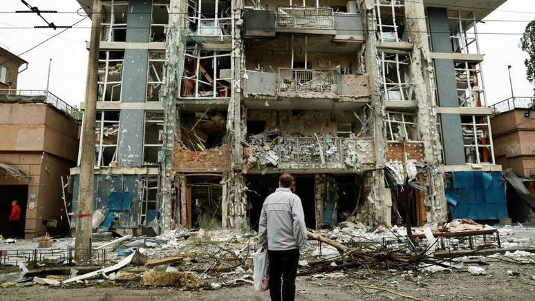 Um morador observa um pr&eacute;dio de apartamentos que foi danificado por um ataque de drone russo em Kiev