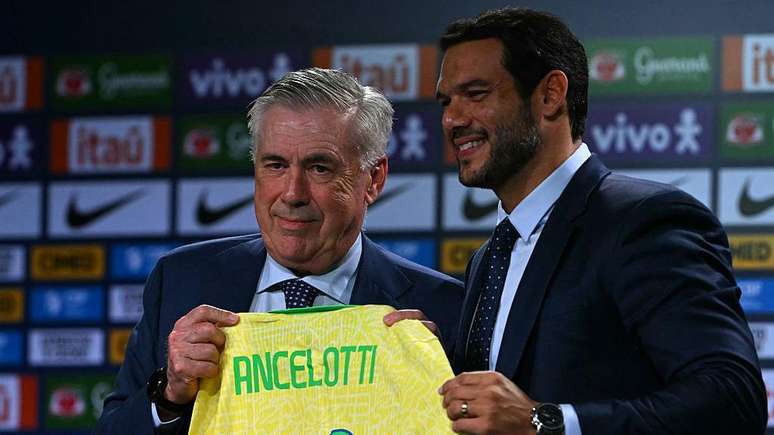 O novo t&eacute;cnico da sele&ccedil;&atilde;o brasileira de futebol, o italiano Carlo Ancelotti (E), recebe a camisa do time das m&atilde;os do presidente da Confedera&ccedil;&atilde;o Brasileira de Futebol (CBF), Samir Xaud, durante sua apresenta&ccedil;&atilde;o oficial em um hotel na Barra da Tijuca, Rio de Janeiro, Brasil, em 26 de maio de 2025