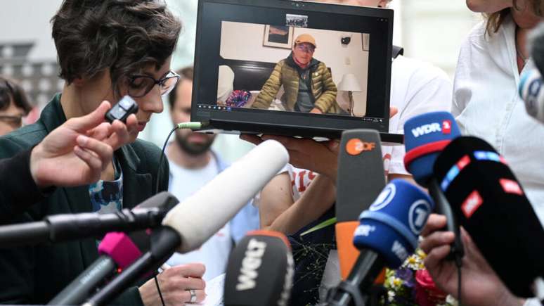 O fazendeiro peruano Saul Luciano Lliuya é visto em um laptop durante uma declaração para a mídia após a sentença do Tribunal Regional Superior em Hamm, oeste da Alemanha, em 28 de maio de 2025.