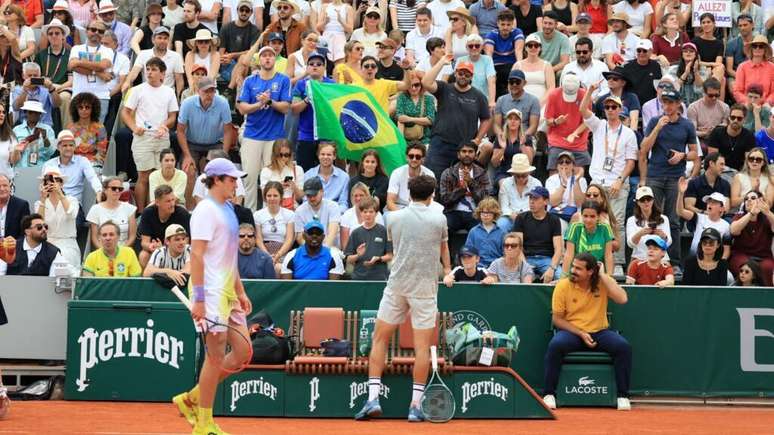 João Fonseca e o francês Pierre-Hugues Herbert em quadra pela segunda rodada da chave principal de simples em Roland-Garros, na tarde desta quinta-feira (29), em Paris.