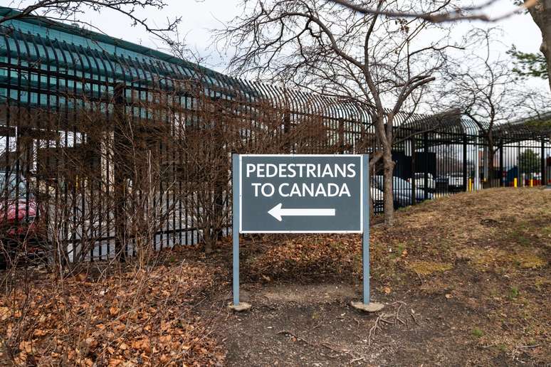 Placa indicando a dire&ccedil;&atilde;o que os pedestres que se dirigem ao Canad&aacute;, saindo dos EUA, devem seguir