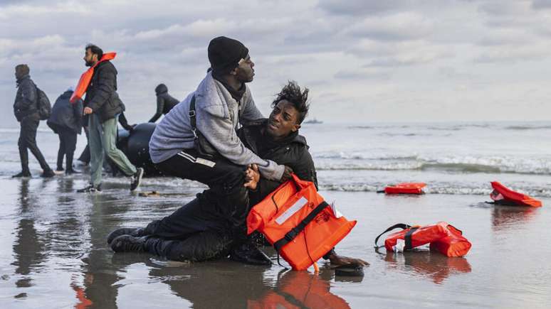 Foto ilustrativa: Um migrante sudanês na areia após deixar o barco de um traficante, que foi esvaziado por policiais franceses para impedir a travessia da Mancha. A cena aconteceu na praia de Gravelines, perto de Dunkerque, no norte da França, em 26 de abril de 2024.