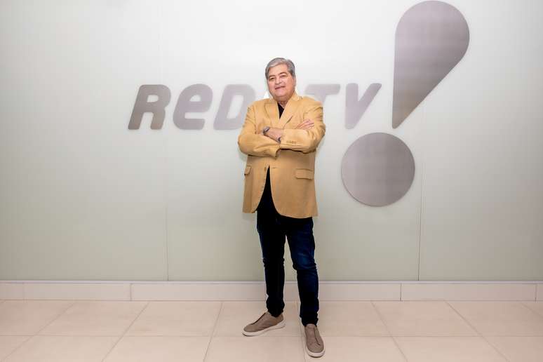 José Luiz Datena posa em frente ao logo da emissora