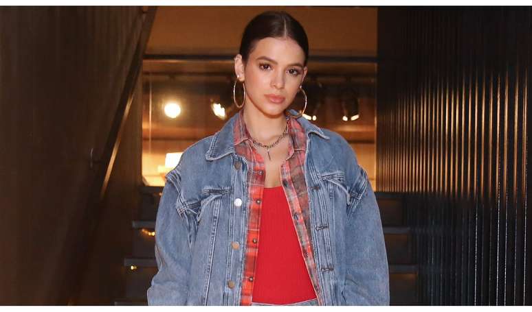 Bruna Marquezine ousou na sobreposição ao usar uma jaqueta jeans por cima de uma blusa xadrez. Ela também investiu em um shortinho jeans com bota.