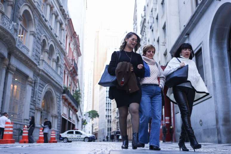 Pedestres caminham na Rua 15 de Novembro no centro de São Paulo em dia de frio
