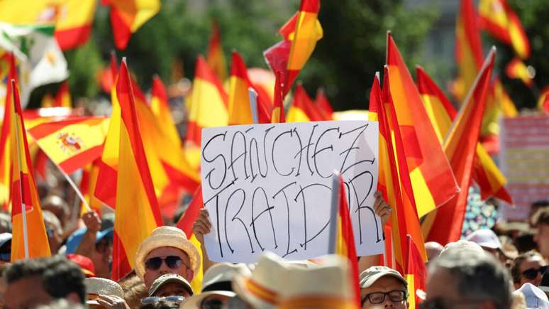 "Sanchez, traidor", diz um cartaz segurado por um manifestante no protesto antigovernamental em Madri, em 8 de junho de 2025.