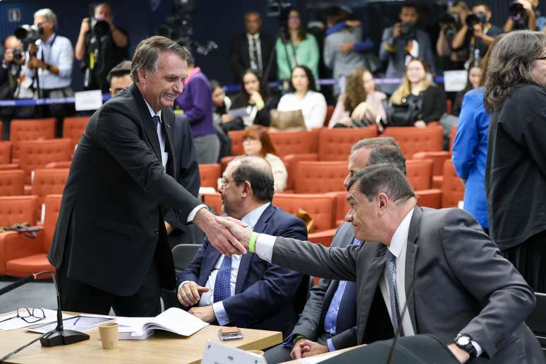 Ex-presidente Jair Bolsonaro cumprimenta sorridente o ex-ministro da Defesa, Paulo Sérgio Nogueira