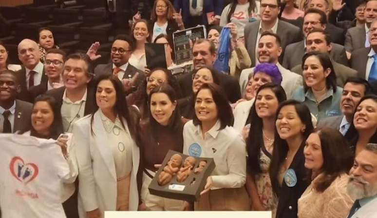 Michelle Bolsonaro ao centro, segurando bonecos que simulam fetos