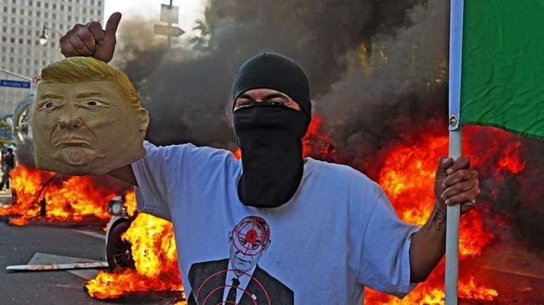 Manifestante segura uma máscara de Donald Trump em Los Angeles, no dia 8 de junho de 2025