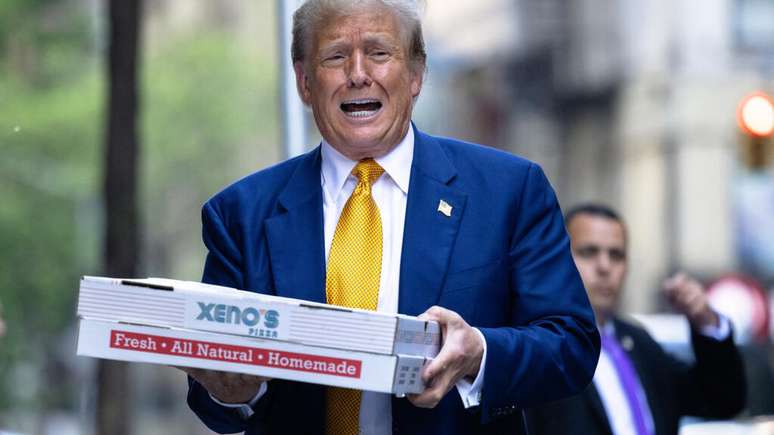 Foto ilustrativa: o então candidato presidencial republicano, Donald Trump, transporta caixas de pizza para o quartel de bombeiros FDNY Engine 2, Battalion 8, em 2 de maio de 2024, na cidade de Nova York.