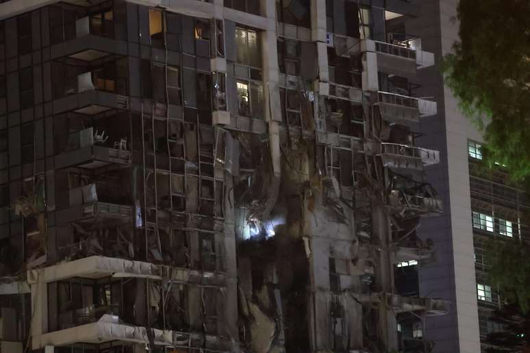 Visão dos danos depois que um dos mísseis disparados pelo Irã em retaliação aos ataques atingiu muito perto do Ministério da Defesa em Tel Aviv, Israel, em 13 de junho de 2025.
