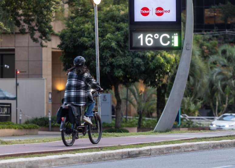 Ciclista se protege do frio na região da Avenida Faria Lima, em São Paulo, na tarde de quinta-feira: frio será menos intenso no final de semana.