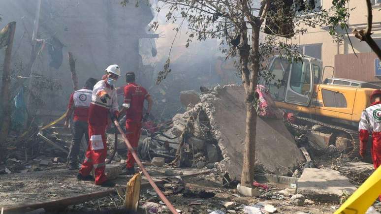 Equipes de emergência trabalham em área atingida por Israel em Teerã (Irã), durante a Operação Leão Crescente