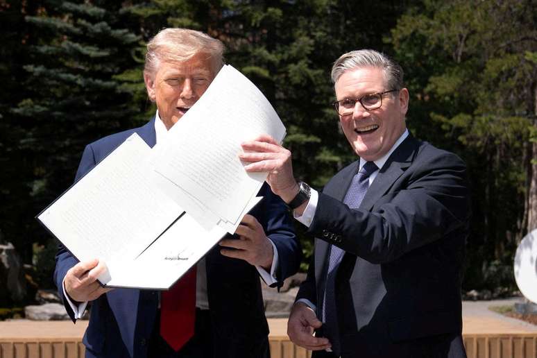 O presidente dos EUA, Donald Trump, e o primeiro-ministro britânico, Keir Starmer, seguram um acordo comercial assinado durante uma reunião na cúpula do G7