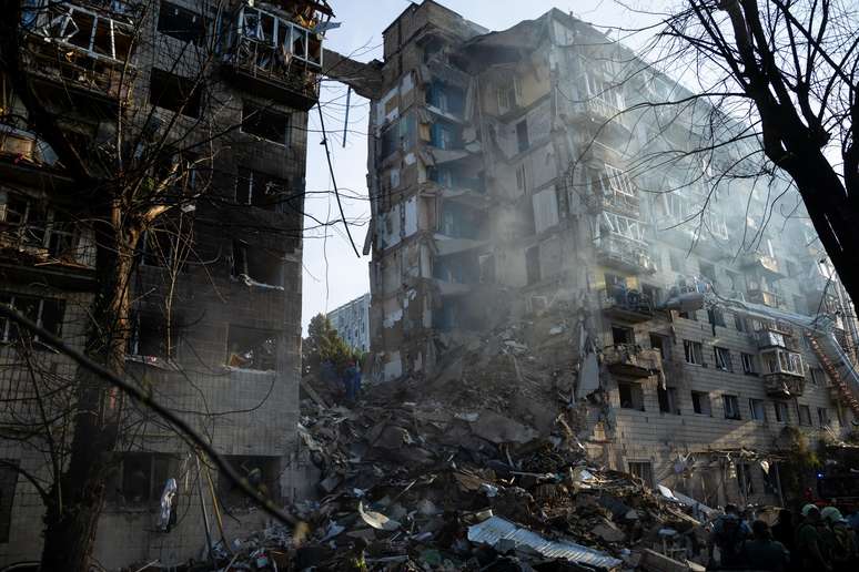 Equipes de resgate realizam operação de busca e salvamento em um prédio residencial parcialmente desabado após um ataque russo com drones e mísseis em 17 de junho de 2025 em Kiev, Ucrânia. 