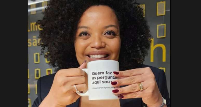 A jornalista com uma caneca com seu bordão: impor-se para ser respeitada pelos entrevistados