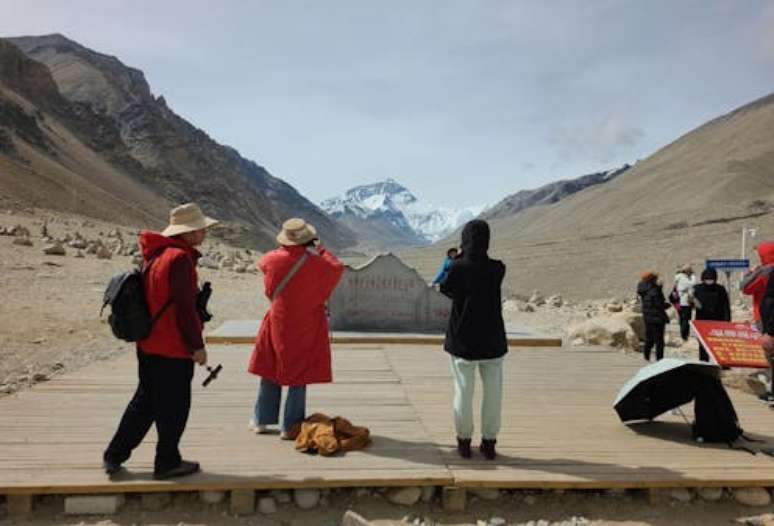 Turistas chineses no acampamento base norte do Everest, em Rongbuk, no Tibete, fotografam a montanha mais alta do mundo. Carl Cater, CC BY-NC-ND