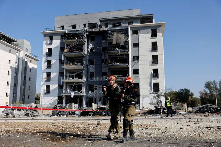 Soldados israelenses caminham em local atingido por ataque iraniano em Be'er Sheva 20/06/2025